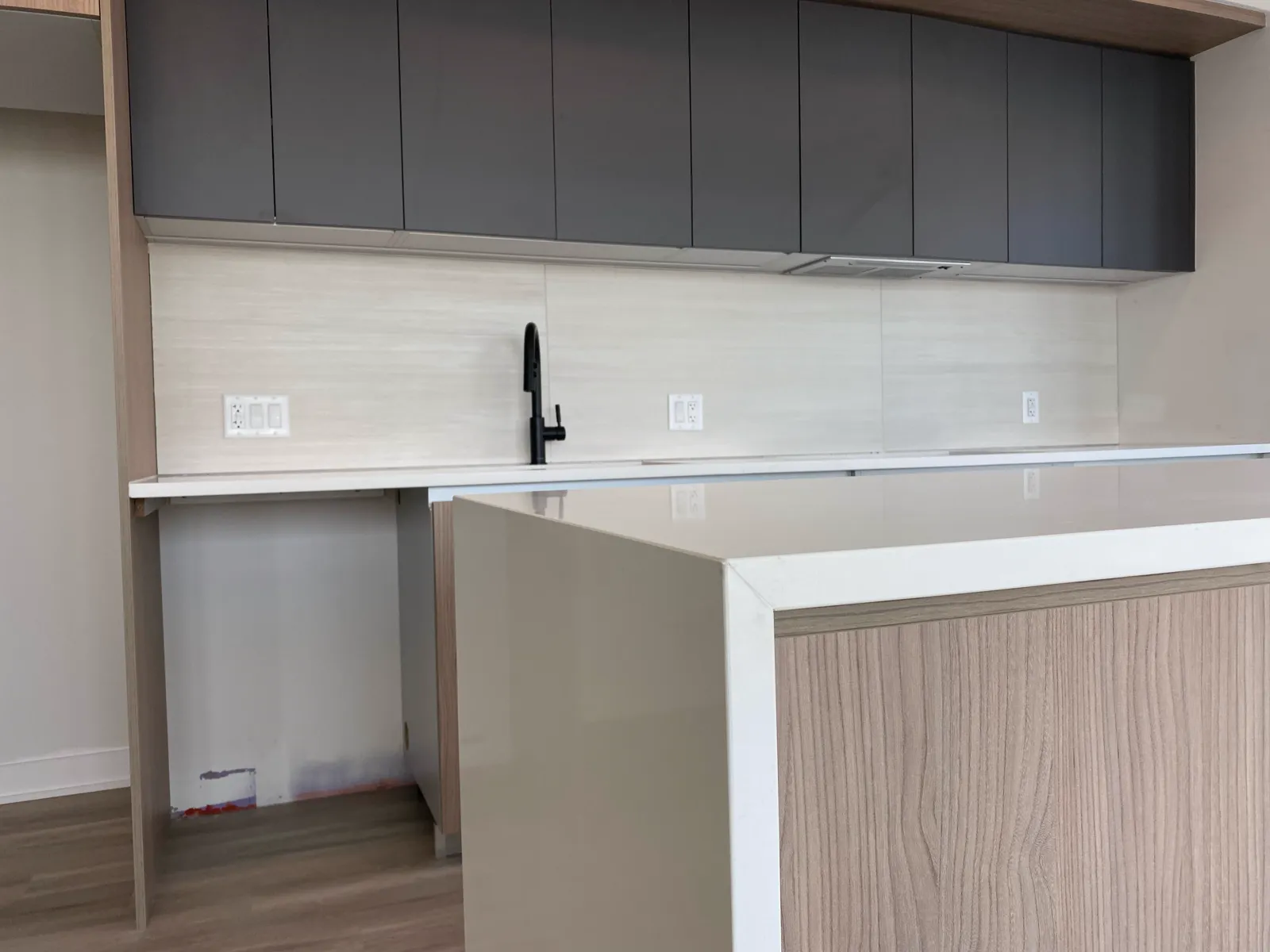 Multifamily residence with a waterfall-edge quartz island and full-height backsplash