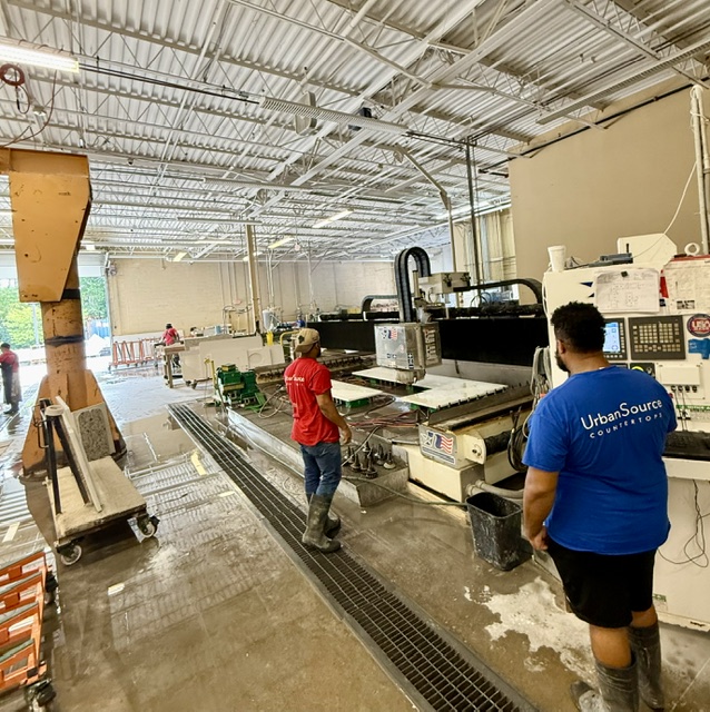 UrbanSource team working beside the stone-cutting equipment
