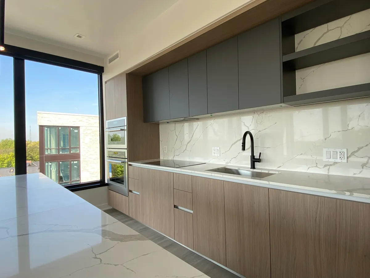 Finished kitchen with a white stone countertop and integrated backsplash